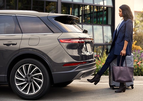 A woman with her hands full uses her foot to activate the available hands-free liftgate. | Pilson Lincoln in Mattoon IL