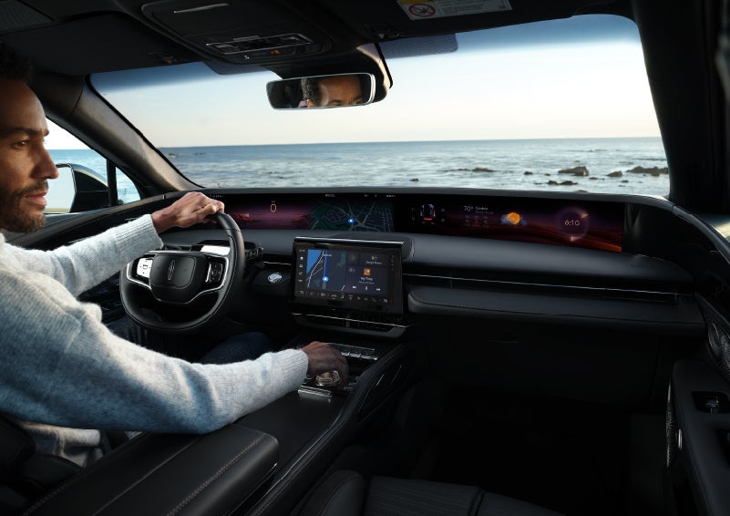 A driver of a parked 2024 Lincoln Nautilus® SUV takes a relaxing moment at a seaside overlook while inside his Nautilus. | Pilson Lincoln in Mattoon IL